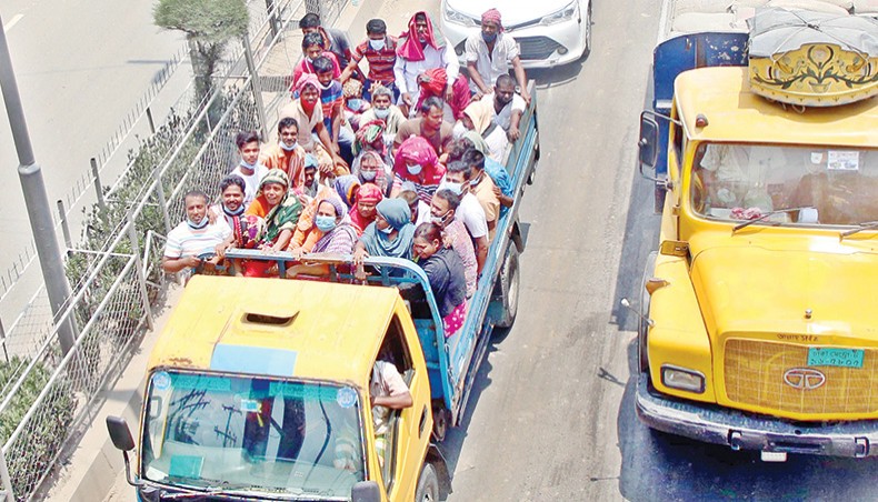 People without bothering to follow the minimum health safety rules travel by a pickup. This photo was taken at Amin Bazar in Dhaka on Friday. — Sony Ramany
