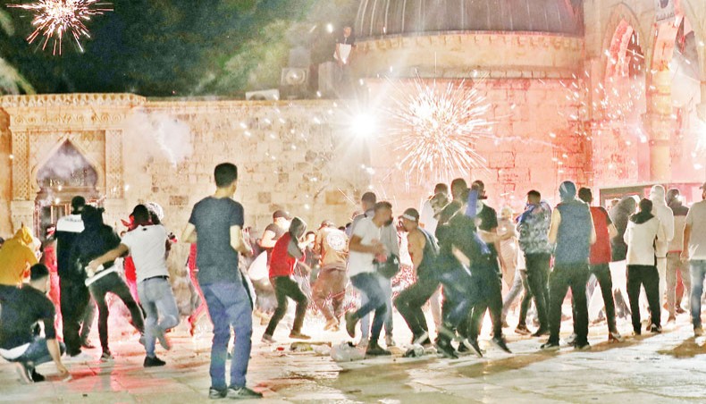 Stun grenades burst in the air amid clashes between Palestinian protesters and Israeli security forces at the al-Aqsa mosque compound in Jerusalem, on Friday night. — AFP photo