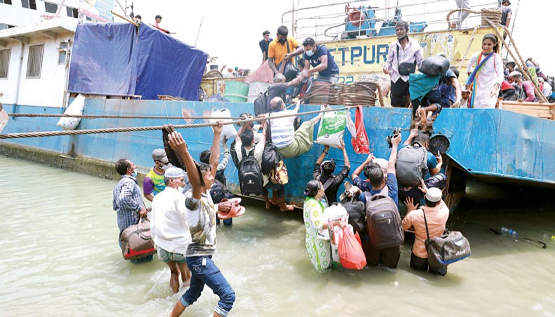 People risk their lives to get on a ferry through the mooring line at Shimulia Ferry Terminal in Munshiganj on Saturday. — Sony Ramany