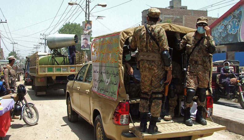 Army soldiers supervise the spraying of disinfectant at a commercial area following new restrictions imposed as a preventive measure against the spread of coronavirus in Pakistan’s southern Sindh province city of Hyderabad on April 30, 2021. — AFP photo