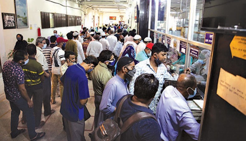 People stand in long queues to avail banking services at the principal branch of a state-owned bank at Motijheel in the capital on Tuesday. A three-day Eid-ul-Fitr holiday for banks begins tomorrow. — New Age photo