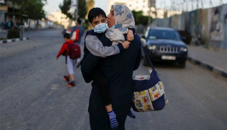 This woman and child are evacuated from a building in Gaza. — BBC