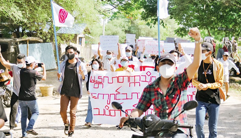 The photo shows protesters holding banners as they march during a demonstration against the military coup in Mandalay, Myanmar on Saturday. — AFP photo