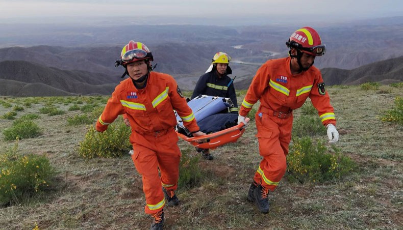 This photo taken on May 22, 2021, shows rescuers carrying equipment as they search for runners who were competing in a 100-kilometre cross-country mountain race when extreme weather hit the area, leaving at least 21 dead, near the city of Baiyin in China's northwestern Gansu province. — AFP