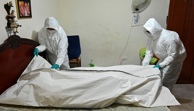 In this file photo taken on July 27, 2020 funeral home workers prepare to carry the corpse of a man who died allegedly from Covid-19 from his home in Cali, Colombia. — AFP photo