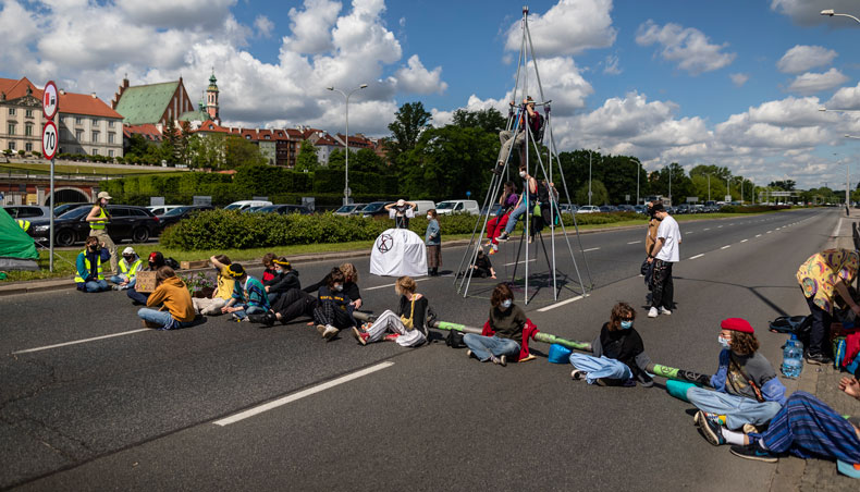 Environmental activists of Extinction Rebellion Youth group form a chain to block one of the main street in the city centre in Warsaw, on May 24, 2021, to draw public attention to the climate crisis and global warming. — AFP photo