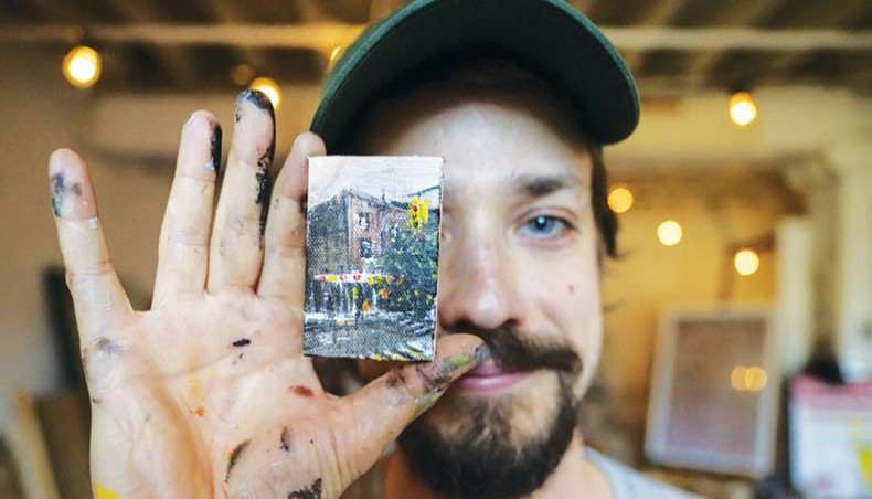 Artist Steve Wasterval poses for a photo with a mini painting at his studio in the Greenpoint district of the New York borough of Brooklyn, on May 25, 2021. – AFP photo