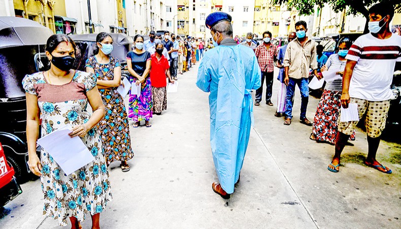 People stand in a queue as they wait to get a dose of the Chinese-made Sinopharm Covid vaccine in Colombo on June 1. — Agence France-Presse/Ishara S Kodikara