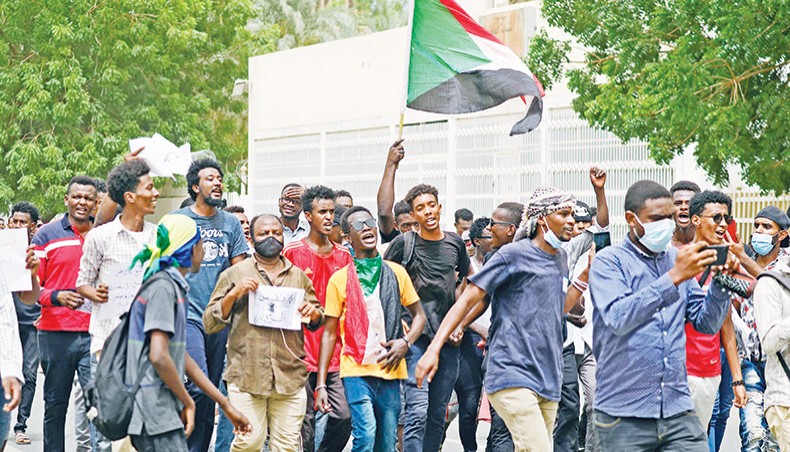 Sudanese protesters shout slogans and wave their country’s national flag as they march in the capital Khartoum, on Thursday, during a demonstration calling for justice for protesters killed during anti-government demonstrations two years ago. — AFP photo