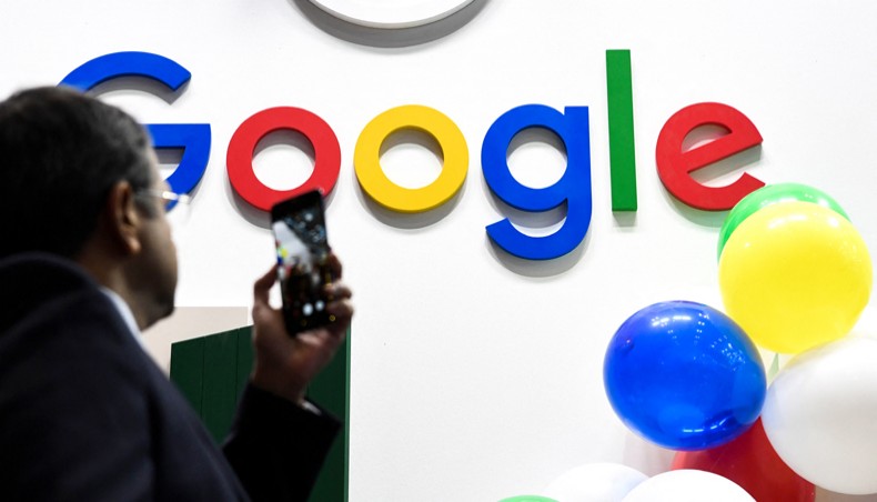 In this file photograph taken on May 16, 2019 in Paris, a man takes a picture with his mobile phone of the logo of the US multinational technology and Internet-related services company Google as he visits the Vivatech startups and innovation fair. France's competition regulator fined Google 220 million euros ($267 million) on June 07, 2021, after finding it had abused its dominant market position for placing online ads, the latest move by European authorities to take tougher stances against US tech giants. – AFP Photo