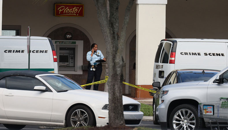 A law enforcement officer stands outside of a Publix supermarket where a woman, child and a man were found shot to death on June 10, 2021 in Royal Palm Beach, Florida. — AFP photo