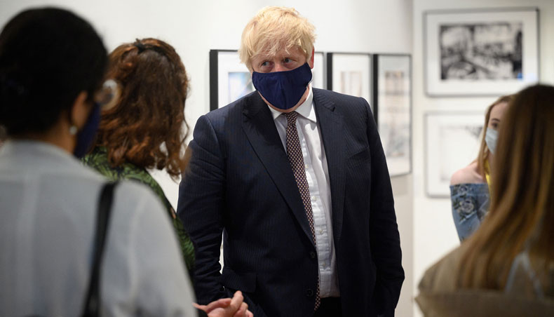 Britain’s prime minister Boris Johnson discusses the foreign aid cap with a member of an engagement group during a visit to Falmouth’s Maritime Museum, where he met and thanked volunteers hosting the media centre for the G7 Summit, in Falmouth, Cornwall on June 10, 2021, ahead of the three-day G7 summit being held from 11-13 June. — AFP photo