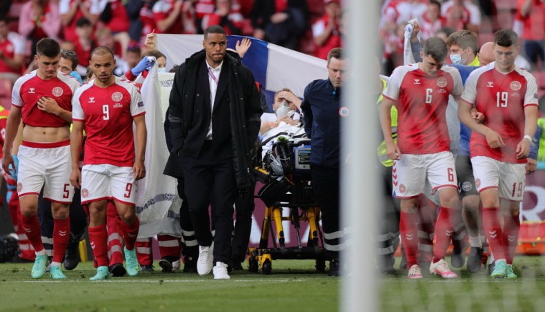 Denmark's players escort midfielder Christian Eriksen (C) as he is evacuated after collapsing on the pitch during their UEFA EURO 2020 match against Finland at the Parken Stadium in Copenhagen on Saturday. —AFP photo