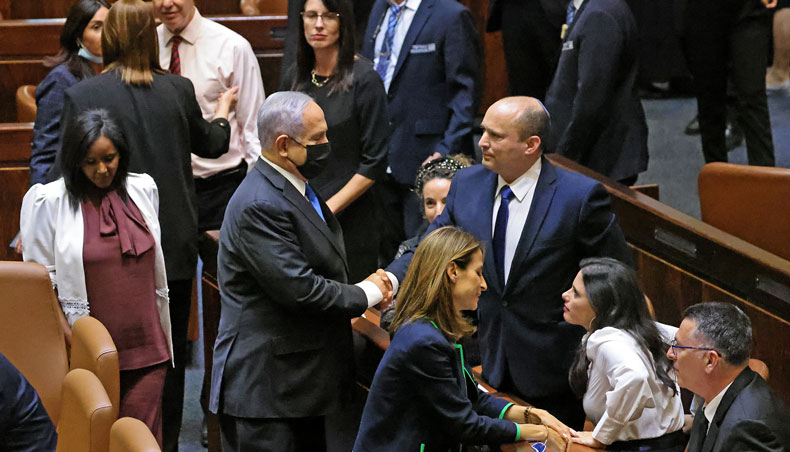 Israel’s outgoing prime minister Benjamin Netanyahu shakes hands with his successor, incoming prime minister Naftali Bennett, after a special session to vote on a new government at the Knesset in Jerusalem, on June 13, 2021. — AFP photo