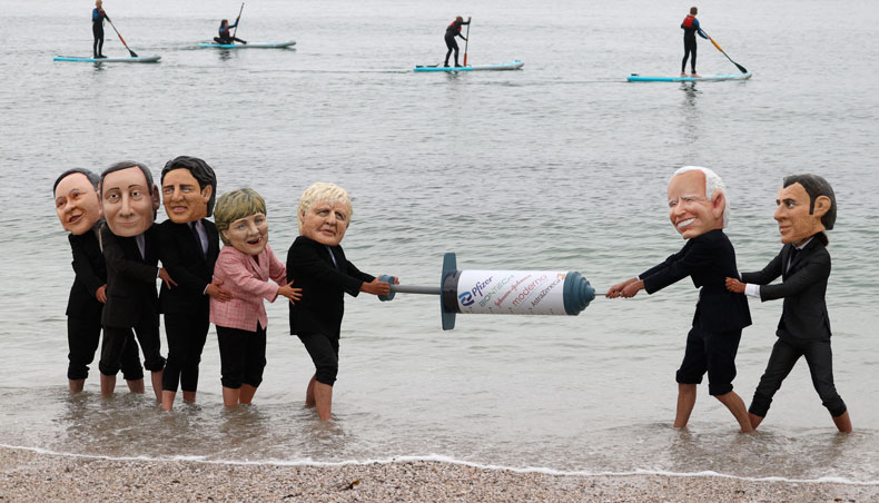 Activists wearing giant heads of the G7 leaders tussle over a Covid-19 vaccine syringe during an action by charity Oxfam to highlight intellectual property for vaccines on Swanpool beach in Falmouth, Cornwall on the sidelines of the G7 summit on June 11, 2021. — AFP photo