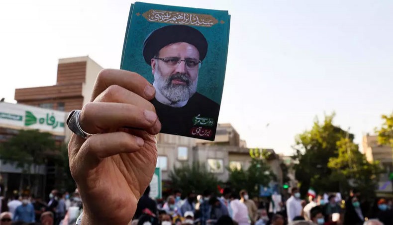 A supporter holds up a photograph of ultraconservative cleric Ebrahim Raisi, the favourite to win Friday's Iranian presidential election, at a rally in Tehran on the final day of the campaign. -- AFP photo