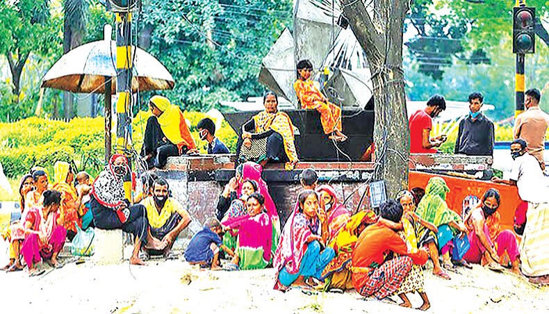 A file photo shows relief-seekers waiting on a street island near the National Press Club in Dhaka as the COVID outbreak pushed the poor to streets to receive food from donors. The poor’s deposits in their bank accounts, opened with Tk 10 as initial deposit, dropped by 32.32 per cent or Tk 104.32 crore to Tk 218.44 crore in March 2021 from Tk 322.76 crore in March 2020, accrording to a Bangladesh Bank report. — New Age photo