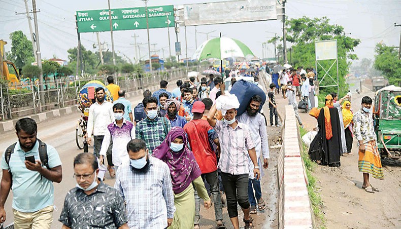 People set out to leave Dhaka travel on foot to catch alternative means of transport from Amin Bazar in Dhaka on Thursday after public transport to and from the capital was suspended to thwart the spread of Covid-19. — Sourav Lasker