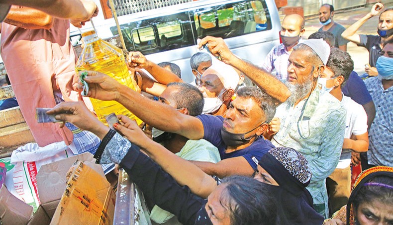 People crowd around a Trading Corporation of Bangladesh truck operating open market sales of essential commodities in front of the National Press Club in the capital on Monday. — Sony Ramany