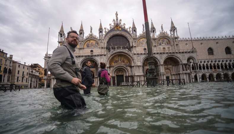 In this file photo taken on November 15, 2019, a general view shows people walking across the flooded St. Mark's Square, by St Mark’s Basilica in Venice, two days after the city suffered its highest tide in 50 years. Venice avoids listing as endangered heritage site, UNESCO announced on July 22, 2021. —AFP photo