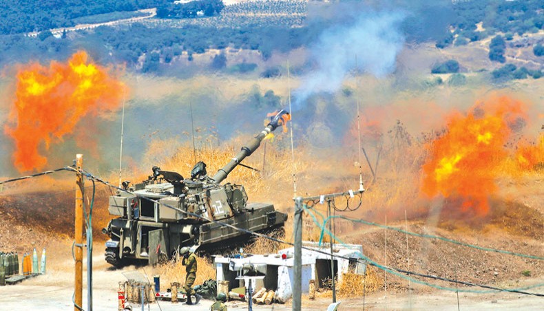 Israeli self-propelled howitzers fire towards Lebanon from a position near the northern Israeli town of Kiryat Shmona following rocket fire from the Lebanese side of the border, on Friday. — AFP photo